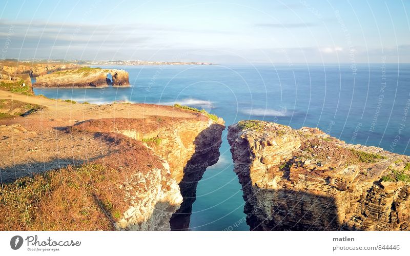 Petrified Nature Landscape Water Sky Clouds Horizon Sunlight Summer Weather Beautiful weather Rock Coast Reef Ocean Blue Brown Approach Cliff land bridge