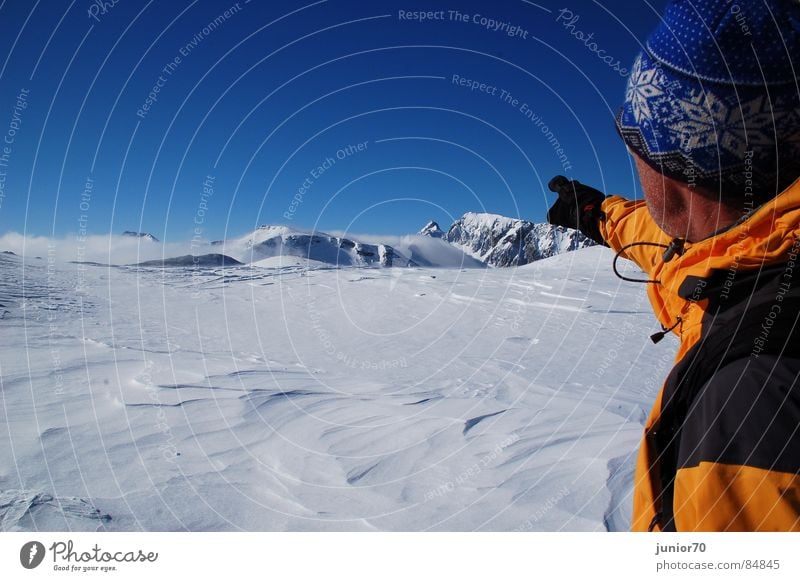 The mountain guide Gloves Cap Cold Mountain guide Slowly Jacket Austria Winter Mountaineering Snow Blue sky Orange Freedom Nature Wind Happy Exterior shot