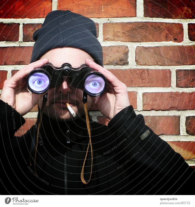 Looking into the distance Binoculars Smoking Cap Whimsical Humor Wall (building) Brick Informer Flirt Strange Telescope Young man Seaman Joy humoristic Eyes