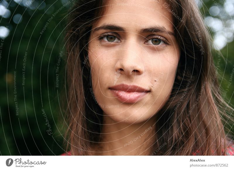 Portrait of a young beautiful woman in front of a tree Young woman Youth (Young adults) Face Eyes 18 - 30 years Adults Park green-eyed Black-haired Long-haired