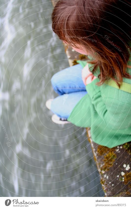 built close to the water Woman Adults Youth (Young adults) Water Coast Brook River Wall (barrier) Wall (building) Observe To fall Sit Jump Sadness Under Anger