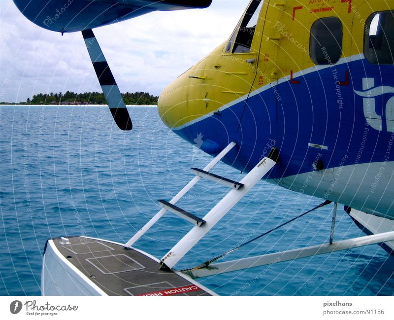 airtaxi Beach Ocean Island Logistics Aviation Water Clouds Coast Airplane Seaplane Blue Yellow Maldives Indian Ocean air taxi Colour photo Exterior shot Morning