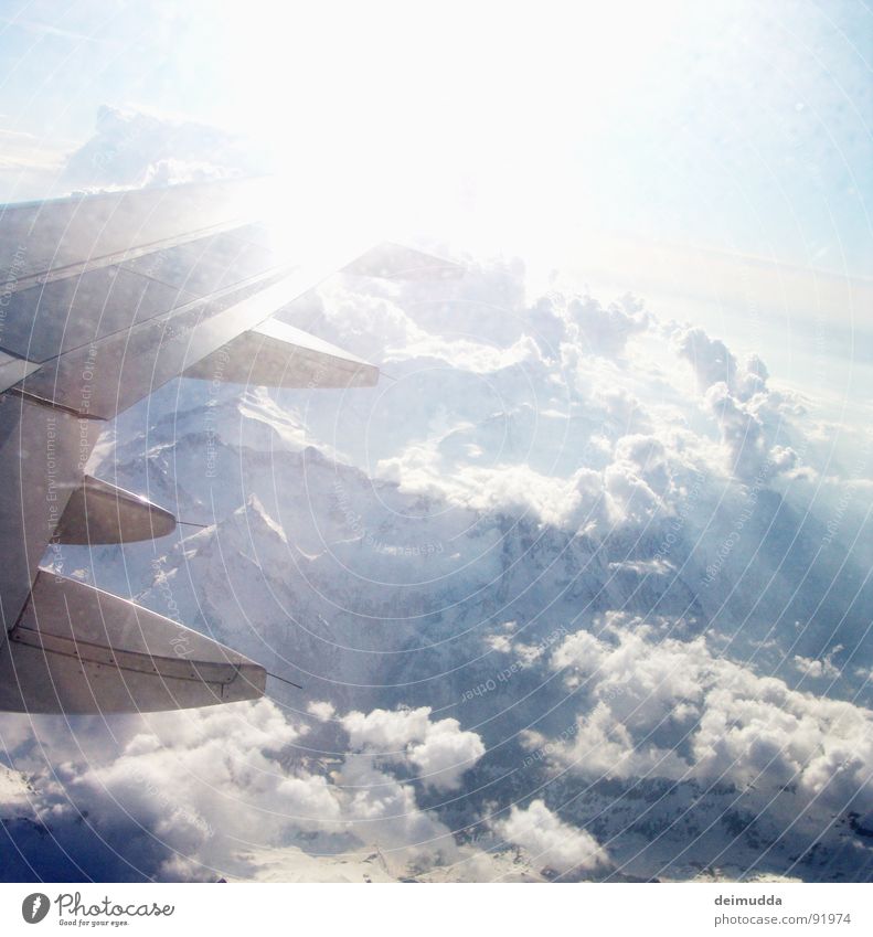 over the clouds... Airplane Clouds Glacier Volcanic crater Covers (Construction) Window Aviation Sky Sun Wing Mountain Ice Blue Tall Above Boeing steal Snow