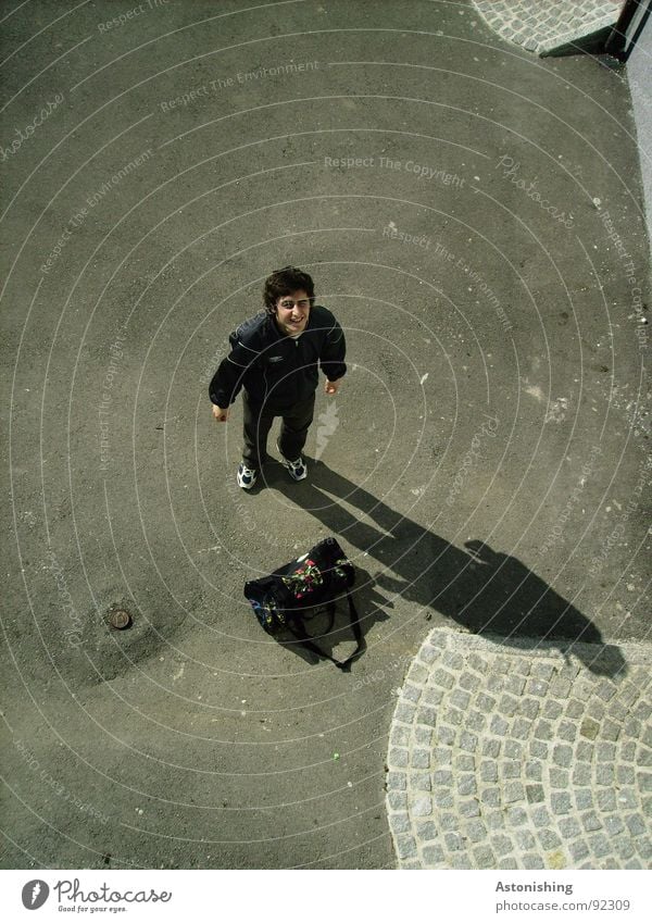 Huh? Human being Masculine Young man Youth (Young adults) Man Adults Hand 1 Places Bag Small Gray Black Surprise Perspective Asphalt Posture Cobblestones Marvel