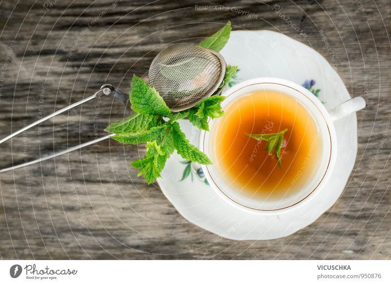 Cup of tea with mint and tea strainer on old wooden table Food Herbs and spices Nutrition Beverage Cold drink Hot drink Tea Crockery Plate Lifestyle Design