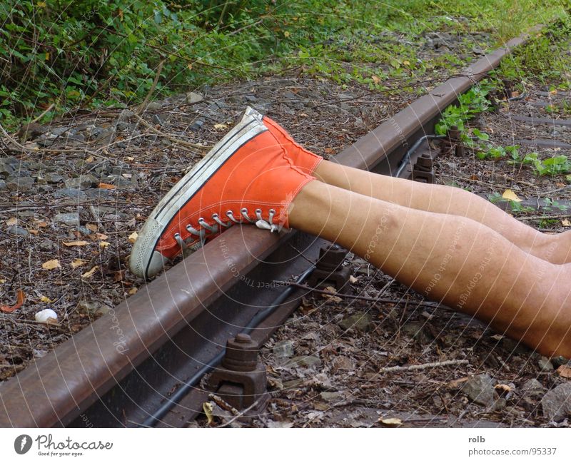 red boots 015 Boots Footwear Railroad tracks Dangerous Red Sneakers Playing Basketball Legs Threat Joy fun Skin Exterior shot