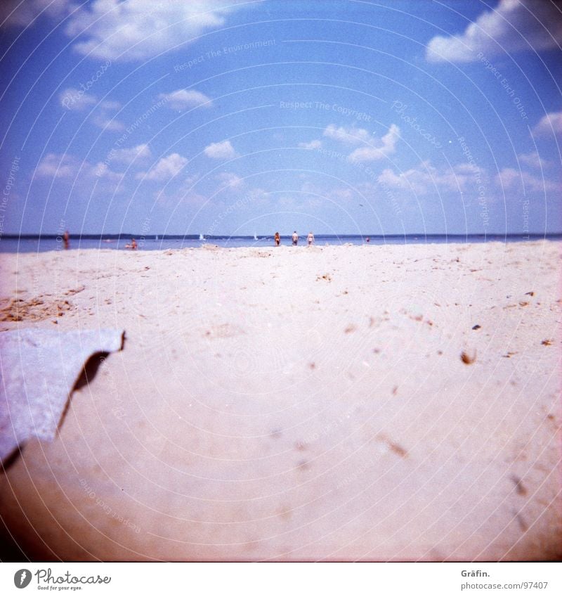 nostalgia for the beach Holga Beach Ocean Physics Waves Clouds Towel Sunbathing Sandy beach Swell Bather Refreshment Cross processing Blur Relaxation