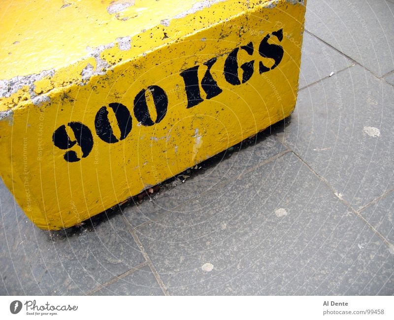 Almost a tonne Kilogram 900 Yellow Strong Town Traffic infrastructure Might Letters (alphabet) Characters kg weight heavy concrete grey gray pavement sidewalk