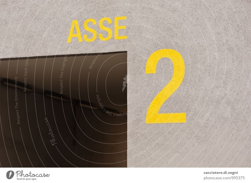 Not really Tunnel Wall (barrier) Wall (building) House number Characters Digits and numbers Threat Dark Cold Gloomy Yellow Gray Concern Fear Fear of the future